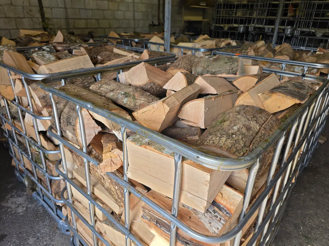 Rijen volle kratten met gekloofd hout in de loods